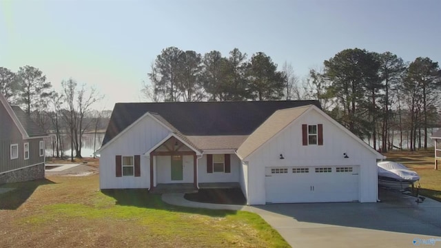 view of front of home featuring a garage, a front lawn, and a water view