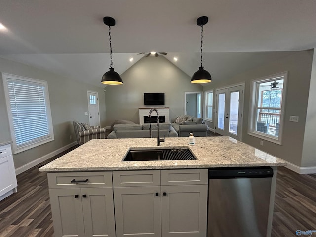 kitchen featuring sink, white cabinetry, light stone countertops, an island with sink, and stainless steel dishwasher