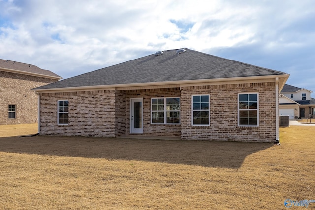 rear view of house featuring a lawn and central air condition unit