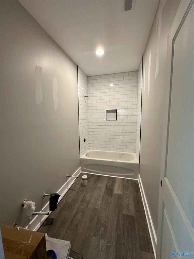 bathroom with wood-type flooring and tiled shower / bath combo