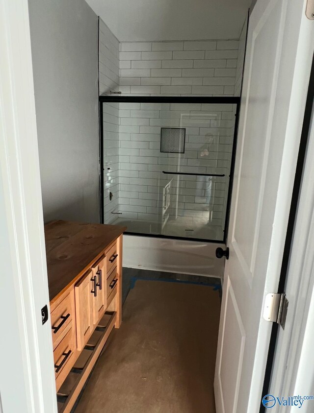 bathroom featuring vanity and enclosed tub / shower combo