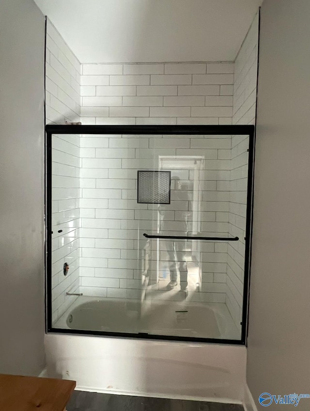 bathroom featuring combined bath / shower with glass door