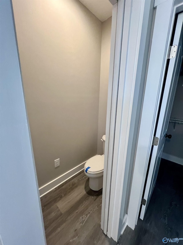 bathroom with hardwood / wood-style flooring and toilet