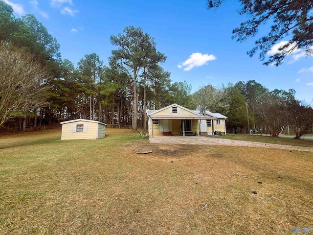 view of front of home featuring a storage shed, a front yard, and a patio area