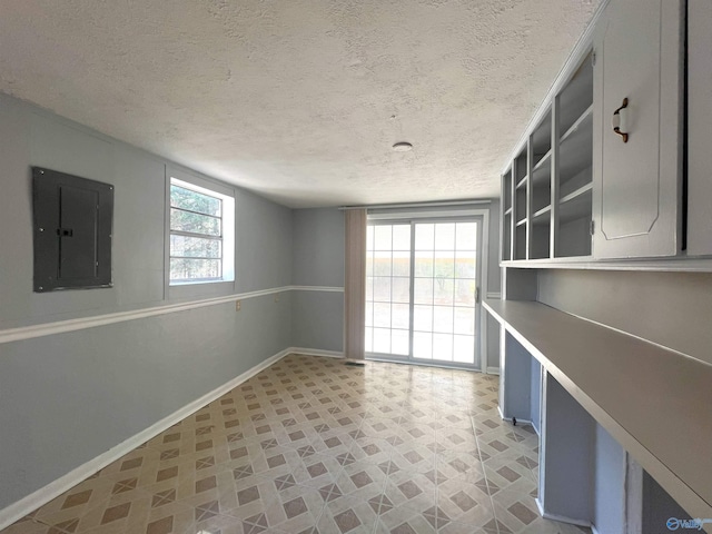 interior space with electric panel and a textured ceiling