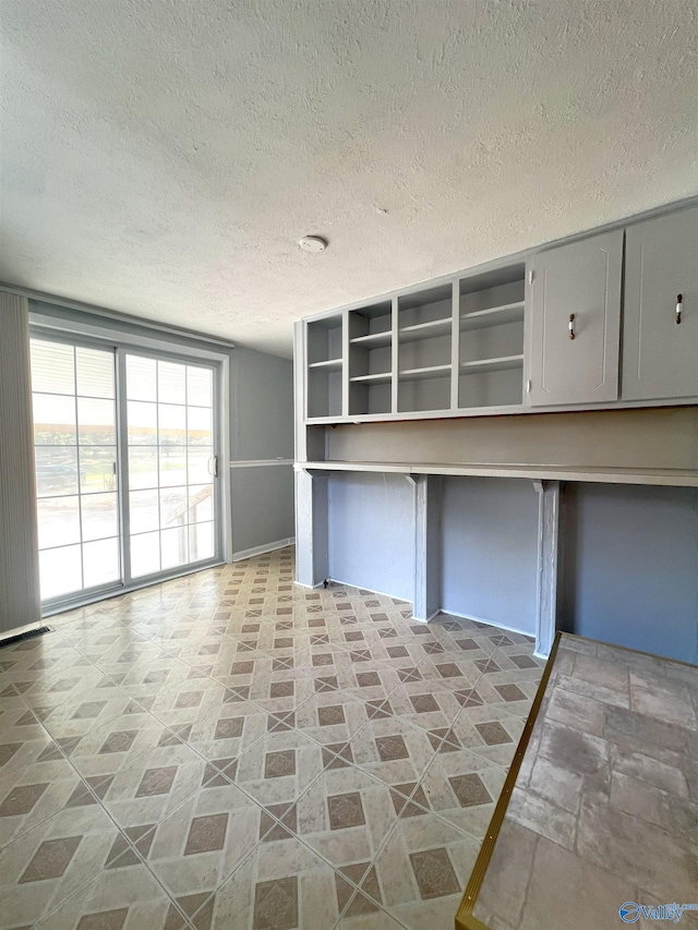 kitchen featuring gray cabinetry and a textured ceiling