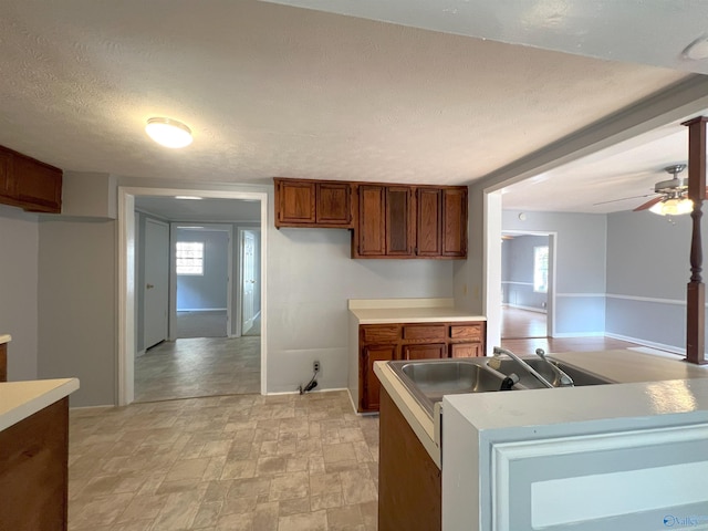 kitchen with ceiling fan, a textured ceiling, and sink