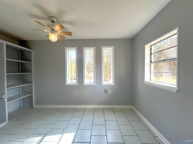 spare room featuring ceiling fan, a textured ceiling, and light tile patterned floors