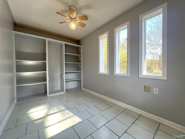 interior space with light tile patterned floors and ceiling fan