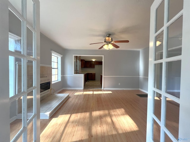 unfurnished living room with light wood-type flooring and ceiling fan