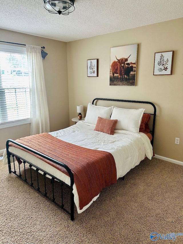 carpeted bedroom with a textured ceiling and baseboards