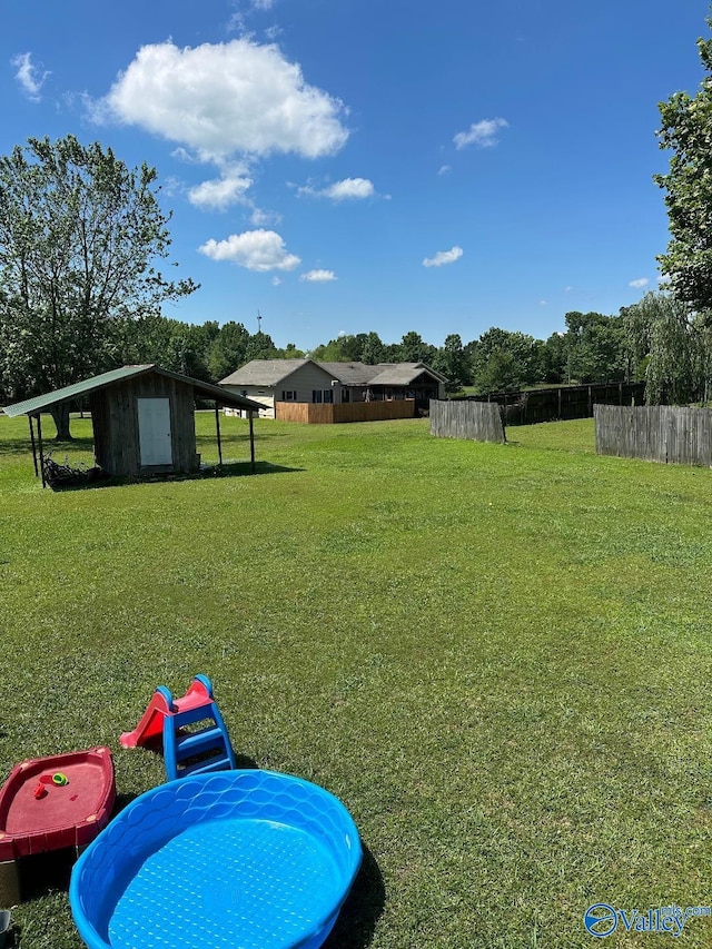 view of yard with fence and an outbuilding