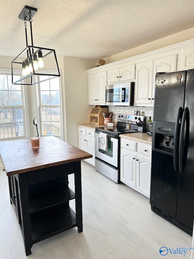 kitchen with stainless steel appliances, white cabinets, light countertops, backsplash, and decorative light fixtures