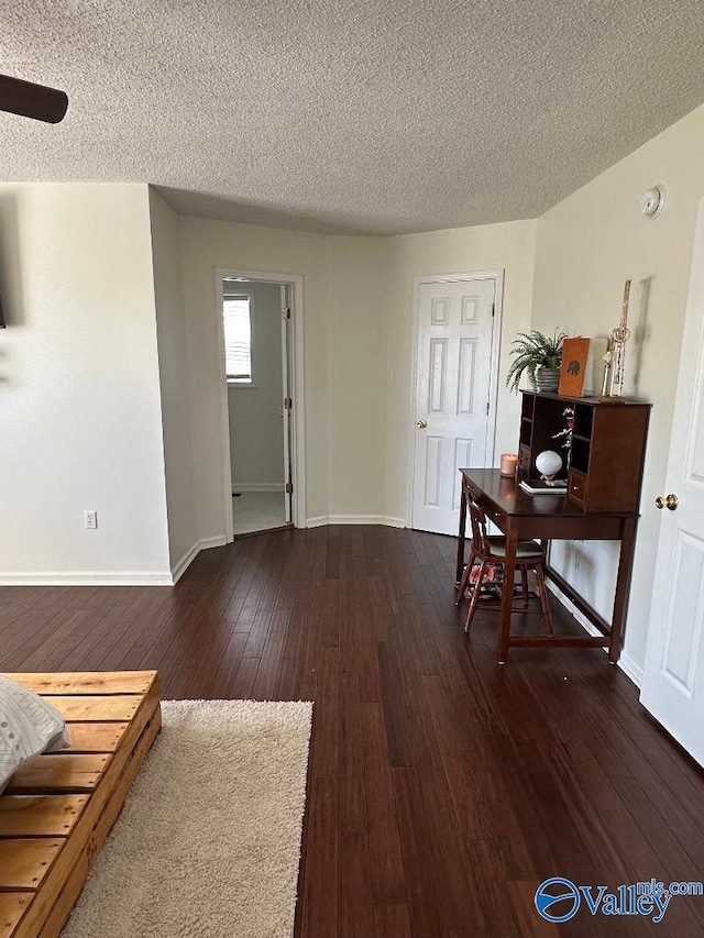 entryway with dark wood-style floors, a textured ceiling, and baseboards