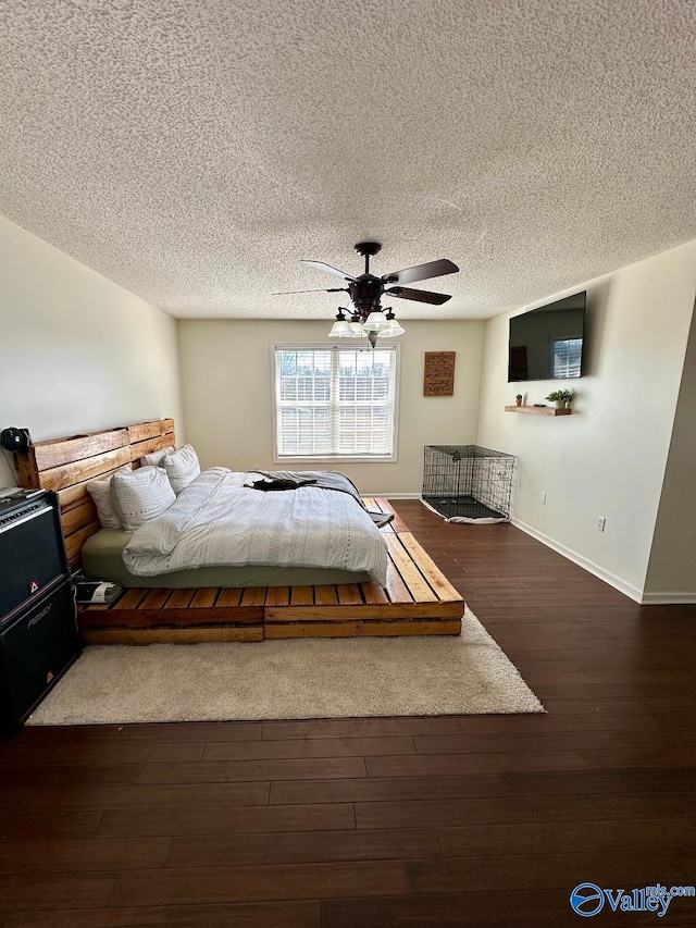 unfurnished bedroom featuring a textured ceiling, dark wood-style flooring, a ceiling fan, and baseboards