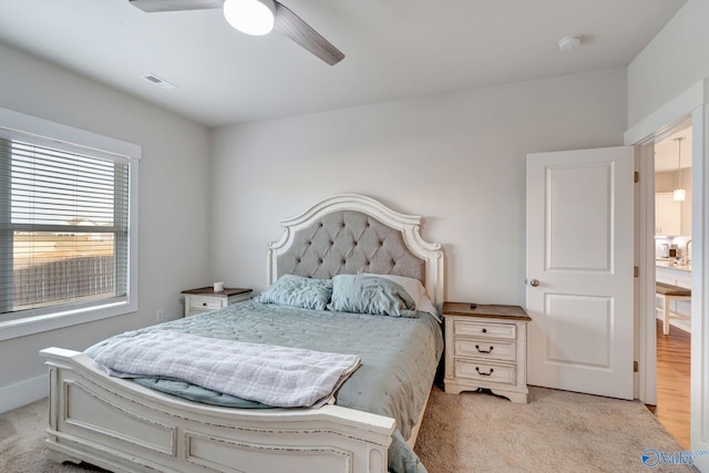 bedroom featuring a ceiling fan, visible vents, light carpet, and baseboards