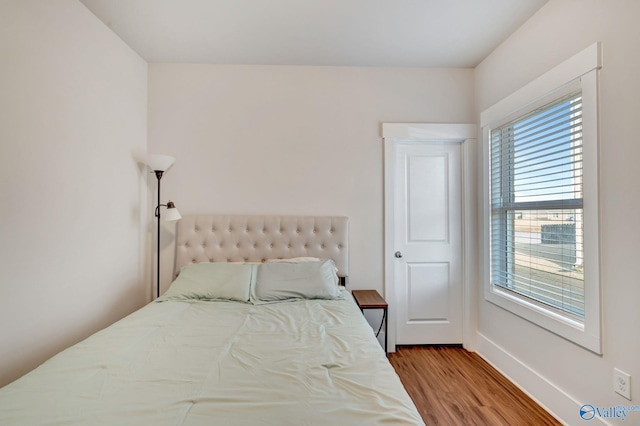 bedroom featuring wood finished floors and baseboards