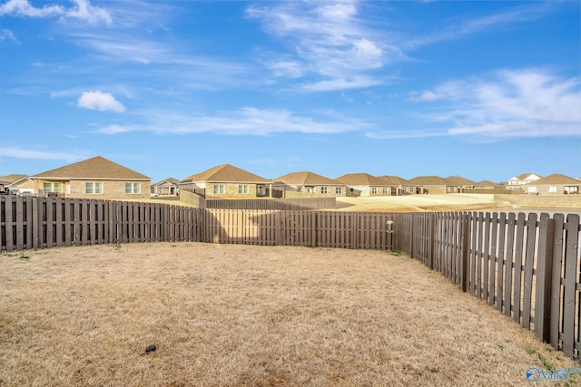 view of yard featuring a fenced backyard and a residential view