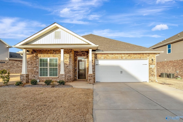 view of front of home with an attached garage, driveway, board and batten siding, and brick siding