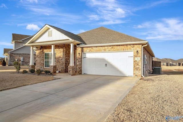 view of front of house featuring brick siding, roof with shingles, central air condition unit, concrete driveway, and a garage