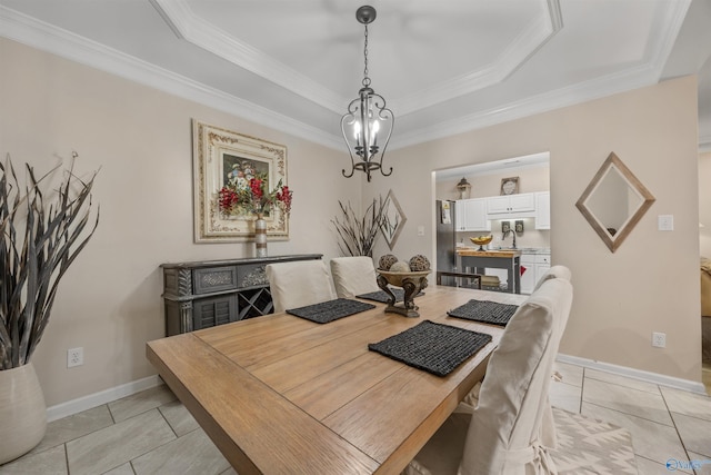 dining room with light tile patterned floors, a chandelier, a tray ceiling, baseboards, and ornamental molding