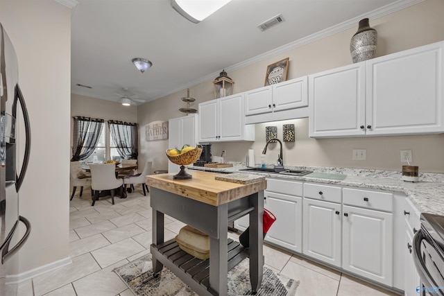 kitchen featuring white cabinets, stainless steel appliances, and ornamental molding