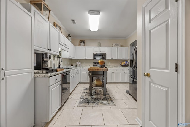 kitchen featuring light tile patterned floors, appliances with stainless steel finishes, white cabinets, visible vents, and crown molding