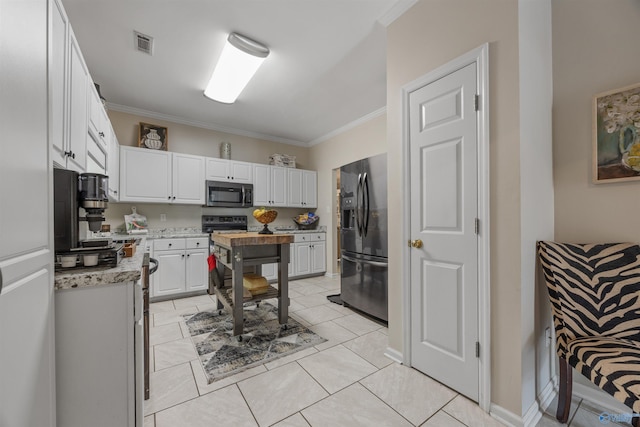 kitchen with light stone counters, white cabinets, visible vents, stainless steel appliances, and ornamental molding
