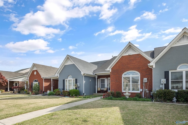 view of front of property with a front lawn and brick siding