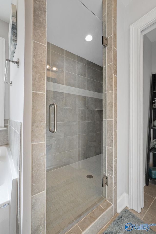 bathroom with a shower with door and tile patterned flooring