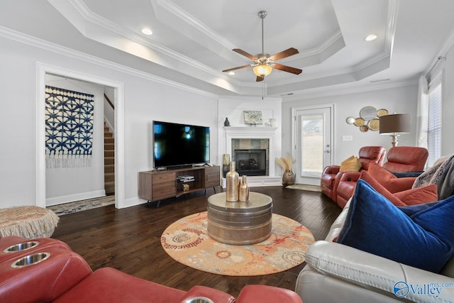 living room featuring plenty of natural light, dark hardwood / wood-style floors, ornamental molding, and a raised ceiling