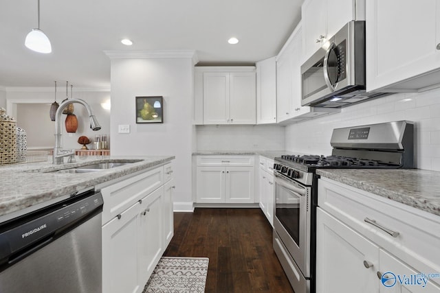 kitchen featuring sink, white cabinetry, stainless steel appliances, and hanging light fixtures