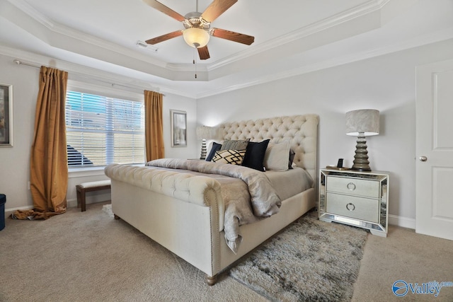 carpeted bedroom featuring ceiling fan, a tray ceiling, and ornamental molding