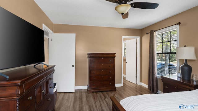 bedroom featuring wood finished floors, a ceiling fan, and baseboards