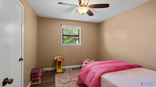 bedroom featuring wood finished floors, a textured ceiling, baseboards, and ceiling fan