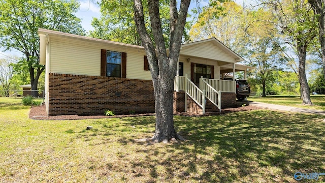 view of front of property featuring stairs, covered porch, a front yard, and brick siding