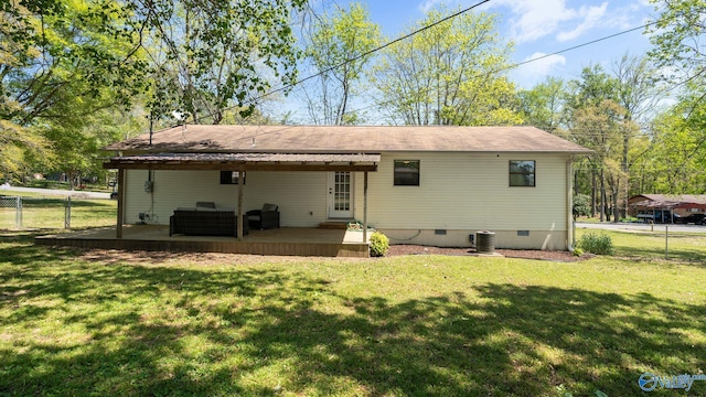 back of house with fence, crawl space, a lawn, and a wooden deck
