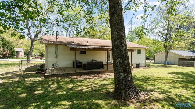 rear view of property featuring an outdoor living space, a wooden deck, a fenced backyard, and a yard