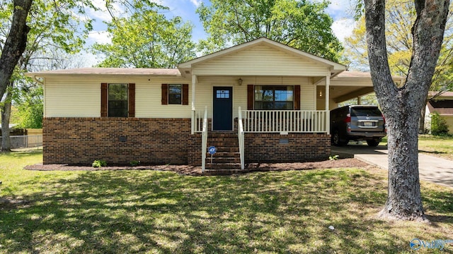 view of front facade featuring a front lawn, driveway, a carport, covered porch, and fence