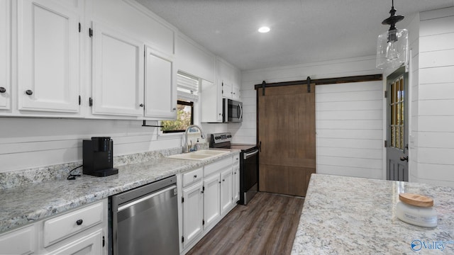 kitchen with white cabinets, dark wood-style flooring, stainless steel appliances, and a sink