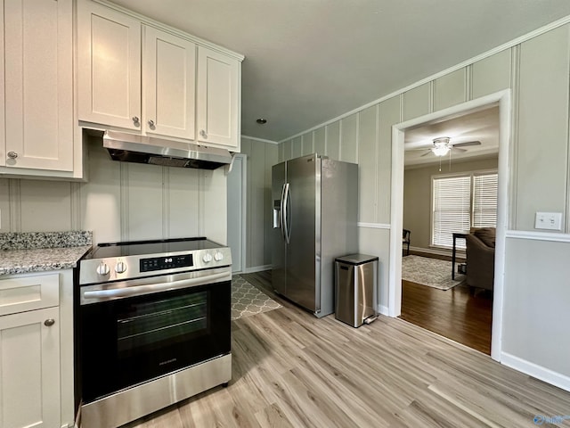 kitchen featuring white cabinetry, stainless steel appliances, light stone counters, and light wood-type flooring