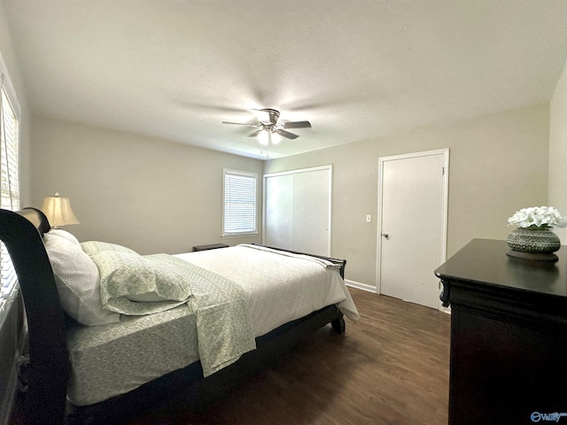 bedroom featuring dark wood-type flooring, ceiling fan, and a closet