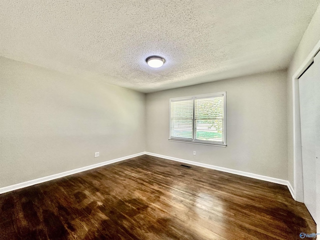 unfurnished bedroom with dark wood-type flooring, a closet, and a textured ceiling