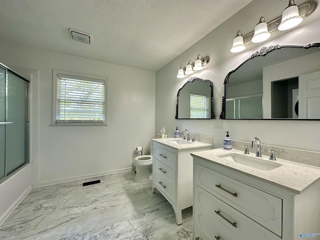 bathroom with vanity, a textured ceiling, and toilet