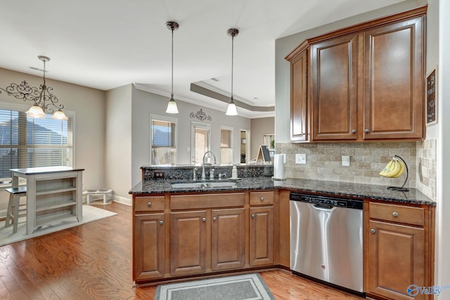 kitchen featuring dishwasher, pendant lighting, a sink, and brown cabinets