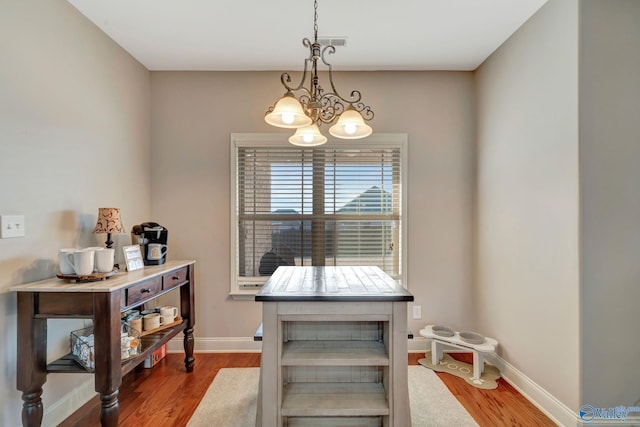 dining room with visible vents, baseboards, and wood finished floors