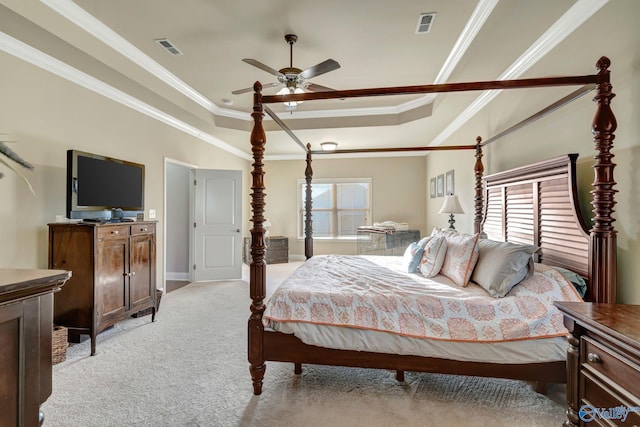 bedroom featuring ornamental molding, a raised ceiling, light colored carpet, and visible vents