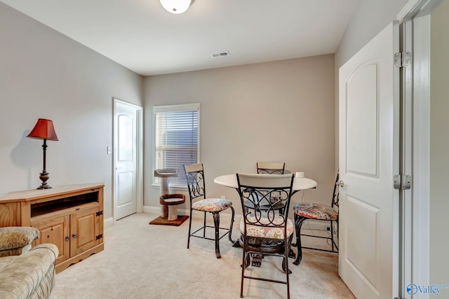 dining room with light carpet, baseboards, and visible vents