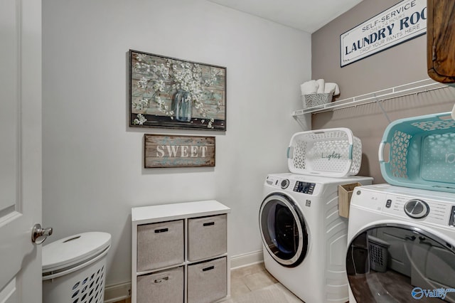 clothes washing area with laundry area, baseboards, washing machine and clothes dryer, and light tile patterned floors