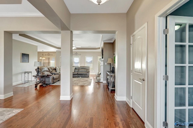 foyer featuring baseboards, wood finished floors, and crown molding